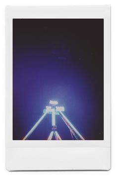 an image of a ferris wheel taken from the ground with polaroid style film in front of it