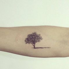 a small tree tattoo on the left arm