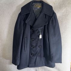 This vintage peacoat from Harbour Park is a true gem for any collector. With a classic navy blue color and a stylish pea coat design, it's perfect for both casual and formal occasions. The outer shell is made of high-quality wool, ensuring both comfort and durability. The size 34 coat is designed for men and features a regular fit. The brand is known for its rare and unique designs, making this a one-of-a-kind piece. It comes with tags and is in excellent, like-new condition. This peacoat is per Navy Double-breasted Long Sleeve Peacoat, Classic Peacoat With Double Button Closure, Navy Double-breasted Long Sleeve Outerwear, Classic Long Sleeve Peacoat With Buttons, Navy Single-breasted Pea Coat, Winter Peacoat With Double Button Closure, Winter Long Sleeve Double-breasted Peacoat, Navy Classic Long Sleeve Peacoat, Classic Navy Pea Coat For Fall