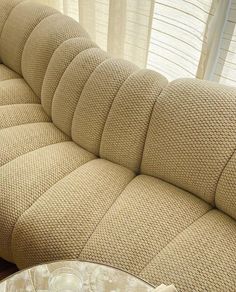 a beige couch sitting in front of a window