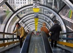 two people riding an escalator in a building