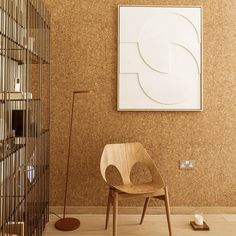 a wooden chair sitting in front of a painting on the wall next to a bird cage