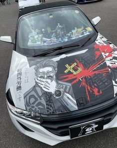 a car that has some pictures on the hood and is parked in a parking lot