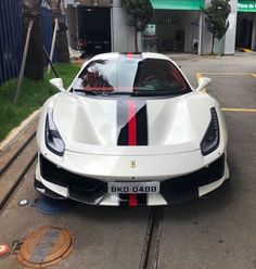 a white sports car parked in front of a building