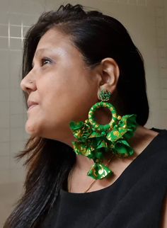 "Handmade emerald green and gold fabric oversized tassels and hoop earrings. These bright green and gold colored bold tassels earrings are made of polyester fabric with beaded post, genuinely beautiful and ideal for the spring summer. These fun earrings are very light in weight but look bold in size. The earrings weigh 17 gms a pair and fall approx. 5\" and 3.5\" wide At Carnation jewellery, each piece is handmade and handcrafted in India. There may be a slight imperfection due to the nature of Handmade Green Tassel Earrings For Party, Green Dangle Hoop Earrings For Celebration, Bohemian Green Earrings For Celebration, Festive Green Hoop Earrings, Traditional Green Tassel Earrings, Green Tassel Earrings As Gift, Green Tassel Earrings With Latkans For Gifts, Green Tassel Drop Earrings For Party, Green Drop Tassel Earrings For Party