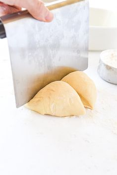 a person cutting bread with a knife on a counter