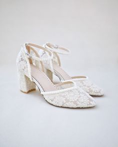 a pair of white shoes with lace on the heel and heels are shown against a white background