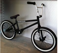 a black and white bicycle leaning against a wall