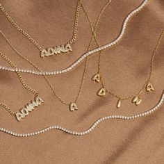 Let the carefree side of your personal style shine bright in Adina's Solid Bubble Name Link Necklace, featuring a cute bubble-font nameplate that dangles from a delicate chain. Customize this gem with the wording of your choice. Pair it with an initial necklace and a couple of cute chokers for a chic, layered look. Product Details Made from Sterling Silver Gold Plated Nameplate Height: 7 MM Chain Thickness: 2 MM Length: 15" +2.5" Capitalized Font This Product Requires 12-18 Business Days To be P Bubble Name Necklace, Bubble Font, Initial Necklace Silver, Silver Link Necklace, Name Necklace Silver, Cuban Link Necklace, Bubble Letter, Bubble Letters, Chain Design