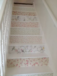 the stairs are decorated with floral wallpapers and decorative hand painted stair treads