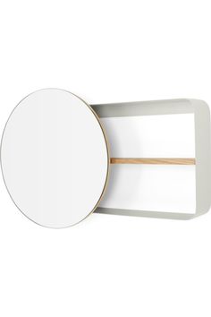 a round mirror mounted on the wall next to a wooden dowel and white board