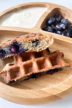 two waffles on a plate with blueberries and yogurt