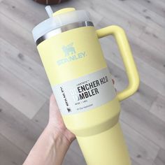 a person holding up a yellow tumbler cup