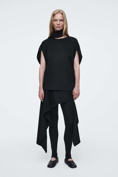 This piece is part of the ATELIER capsule; an exploration of the modern wardrobe, founded on the principles of luxury and exceptional design.  CUTThe ATELIER designers draw from the sartorial language of ballet for AW24. This softly draped skirt is cut in an asymmetric shape that creates a sense of movement and lends itself to a number of looks – style it as a mini, with the matching top or layered over pants for a modern take.  CLOTHOffered in an enduring carbon tone, this piece is crafted from Scarf Blouse, Asymmetric Skirt, Latest Skirts, Leather Midi Skirt, Draped Skirt, Modern Wardrobe, Black Midi Skirt, Asymmetrical Skirt, Wool Skirts