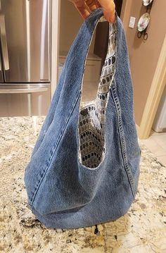 someone is holding up a purse made out of jeans