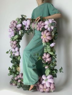 a woman standing in front of a floral letter