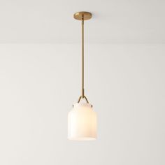 a light fixture hanging from the ceiling in a room with white walls and flooring