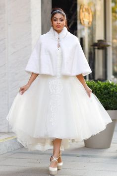 a woman walking down the street wearing a white dress