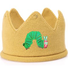 the very hungry caterpillar knitted crown hat is yellow and has a green caterpillar on it