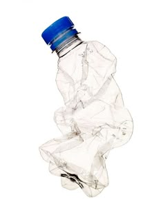 a plastic water bottle with a blue cap on it's top is in the air