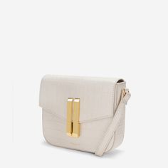 Ideal for day-to-night transitioning, The Small Vancouver is expertly handcrafted in beautiful, sustainable materials. It features our signature double-bar gold-plated lock closure and an adjustable strap and can be worn crossbody or over the shoulder. The interior features a single cotton lined compartment, with a zip pocket for daily essentials. Timeless White Flap Bag For Evening, Elegant White Structured Shoulder Bag, White Structured Leather Bag, Elegant White Satchel Saddle Bag, Elegant White Shoulder Saddle Bag, Timeless White Rectangular Flap Bag, Timeless White Rectangular Shoulder Bag, White Rectangular Saddle Bag With Removable Pouch, Timeless White Crossbody Shoulder Bag