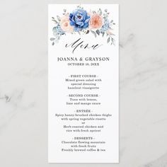 a wedding menu with blue flowers and greenery