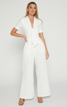 Get ready to turn heads in the Naples Wrap Front Jumpsuit In White! This wide leg jumpsuit is perfect for those casual summer days or dress it up with some heels for a night out. Made from 100% cotton, this jumpsuit is lightweight and breathable, keeping you cool and comfortable all day long. With its flattering wrap front detail and short sleeves, this jumpsuit will accentuate your figure in all the right places. So go ahead, embrace your playful side and add this flirty white jumpsuit to your Spring Trendy Cotton Jumpsuits And Rompers, Trendy Cotton Jumpsuits And Rompers For Spring, Trendy Cotton Jumpsuits And Rompers For Summer, Trendy Wide Leg Cotton Jumpsuits And Rompers, Trendy Wide-leg Cotton Jumpsuits And Rompers, Trendy Cotton Wide Leg Jumpsuits And Rompers, Trendy Wide-leg Cotton Jumpsuit, Trendy Wide Leg Jumpsuits And Rompers For Spring, Trendy Wide-leg Jumpsuits And Rompers For Spring