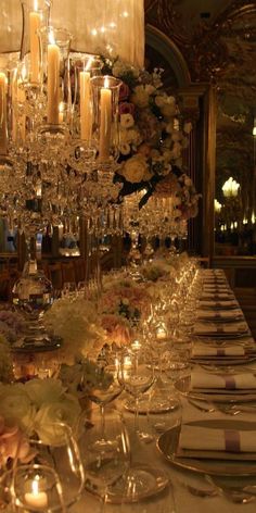 a long table is set with candles and flowers for an elegant dinner or reception in a fancy setting