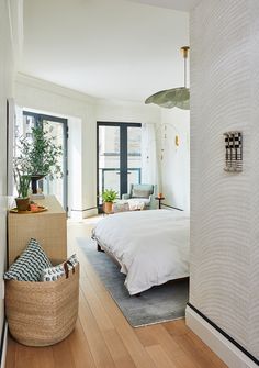 a bedroom with white walls and wood floors