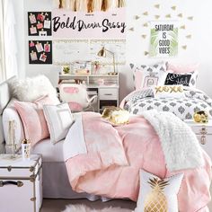 a bedroom with pink and white bedding, gold accents and decorations on the wall