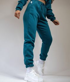 Pea Street has handmade the best quality loungewear for you peas. These teal blue brush back sweatpants joggers are so comfy and go perfect with the matching crop top and sweatshirt. Elasticated cuffs and waistband with matching cord and pockets. model size 8-10 wearing size 10 handmade to order, high quality fabric, super soft. comes in petite length. Blue Relaxed Fit Sweatpants For Fall, Blue Joggers For Fall Loungewear, Blue Sweatpants With Elastic Waistband, Blue Fall Sweatpants With Elastic Waistband, Blue Tracksuit With Ribbed Cuffs For Loungewear, Green Joggers With Elastic Cuffs For Loungewear, Green Elastic Cuffs Joggers For Loungewear, Green Athleisure Tracksuit For Loungewear, Comfortable Blue Joggers With Elastic Waistband