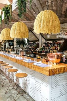 the bar is lined up with chairs and hanging lights