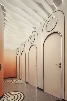 an artisticly designed hallway with white walls and circular designs on the wall, along with black and white flooring