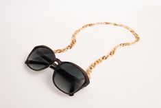 [off she went on an adventure of her own]Whether you're on a tropical island or just strolling through the city, this eyewear chain will keep your shades from going on an adventure of their own, all while looking stylish af. The chunky acrylic cuban chain is accented with a gold and clear rubber loop end, making it both stylish and functional. So, what are you waiting for?•Chunky acrylic cuban chain•Gold + clear rubber loop end Trendy Glasses Chains With Chain Strap, Trendy Summer Glasses Chains With Chain Strap, Trendy Gold Glasses Chains For The Beach, Trendy Summer Chain Necklace With Adjustable Chain, Trendy Summer Adjustable Chain Necklace, Trendy Summer Glasses Chains For Vacation, Trendy Adjustable Chain Necklace For Summer, Trendy Adjustable Glasses Chains For Vacation, Megan Walker