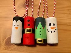 four toilet paper roll snowmen with christmas decorations on them