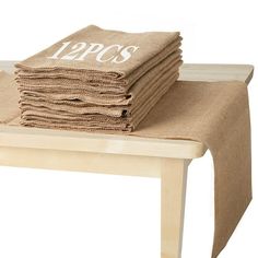 a stack of towels sitting on top of a wooden table covered in burlap