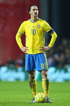 a soccer player standing on the field with his hands on his hips