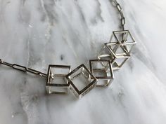 "Make a statement with this unusual necklace. Forming part of my cube collection, this necklace makes quite the impact. I always get compliments when I wear this necklace and I love it! It would make a great unique wedding day necklace too. Each cube is interlocked by sawing a side, hooking the next cube in and then soldering the cube back together. It's quite a process! Forming part of the cube collection by Silver Sculptor, this necklace comes in various chain lengths. The Cube Collection has Contemporary Metal Necklace For Gift, Sterling Silver Geometric Jewelry For Formal Occasions, Formal Sterling Silver Geometric Jewelry, Formal Geometric Sterling Silver Jewelry, Modernist Geometric Jewelry For Gifts, Contemporary Square Jewelry For Gifts, Contemporary Jewelry As A Gift With Unique Variations, Contemporary Necklace With Unique Design For Gift, 3d Necklace