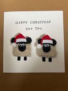 two sheep wearing santa hats on top of a white card that says happy christmas eve two