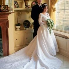 a bride and groom standing in front of a window