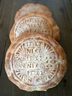 three round breads sitting on top of a wooden table