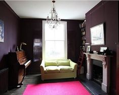 a living room filled with furniture and a fire place next to a fireplace covered in a pink rug