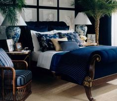 a bed room with a neatly made bed next to a chair and table in front of a window