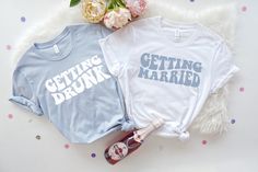 two t - shirts that say getting drunk and getting married next to some confetti