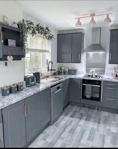 a kitchen with gray cabinets and marble counter tops