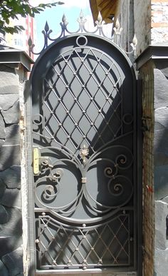 an iron gate is shown in front of a stone building