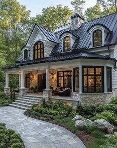 a large white house with lots of windows and stone steps leading up to the front door