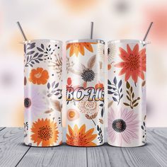 three floral tumblers with straws in them sitting on a table