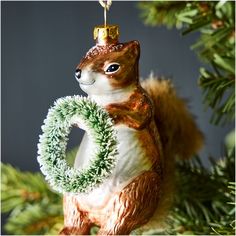 an ornament shaped like a squirrel holding a wreath in it's paws