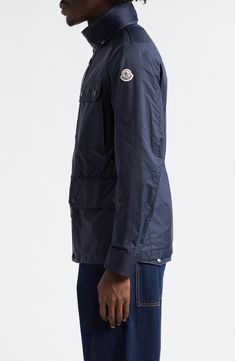 A quartet of large patch pockets inspired by field jackets enhance the utilitarian appeal of this jacket crafted of Moncler's water-repellent rainwear fabric. A stowaway hood and internal drawstring waist add to the functionality of the adventure-ready piece. Two-way front-zip closure with button storm placket Stand collar; stowaway hood Adjustable snap-tab cuffs Chest snap-flap patch pockets; front snap-flap patch pockets Internal drawcord waist 100% polyamide Machine wash, line dry Imported De Field Jacket, Rain Wear, Stand Collar, Repellent, Water Repellent, Drawstring Waist, Designer Clothing, Nordstrom, Navy